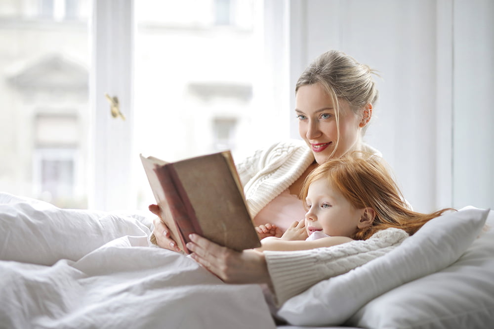 Mother and daughter on bed reading